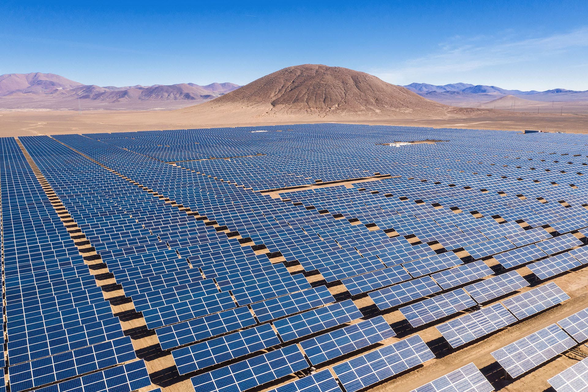 Aerial view of hundreds solar energy modules or panels rows along the dry lands at Atacama Desert, Chile. Huge Photovoltaic PV Plant in the middle of the desert from an aerial drone point of view-1472073983