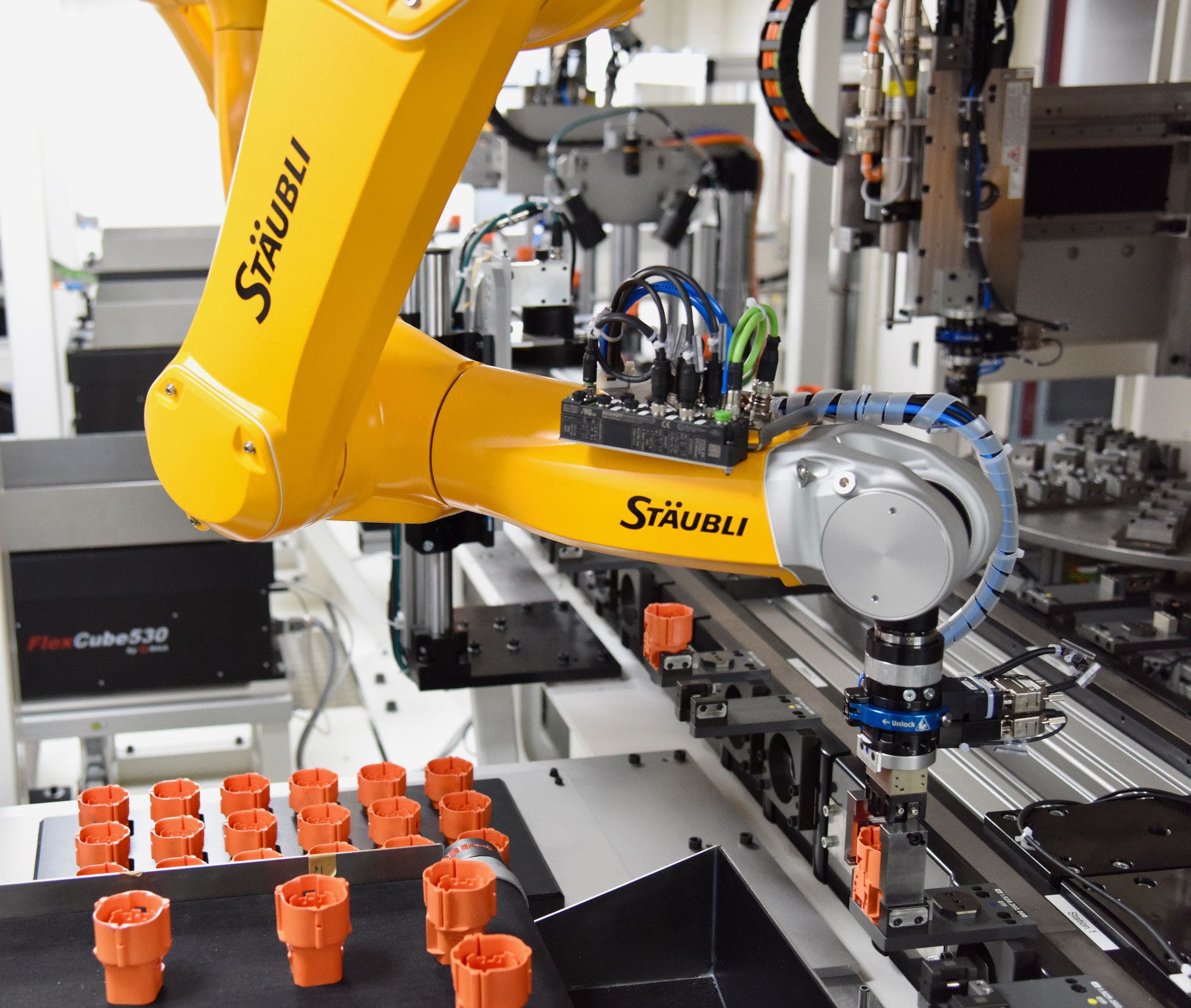 The first of the six installed TX2-60L robots places a connector housing into the workpiece carrier.