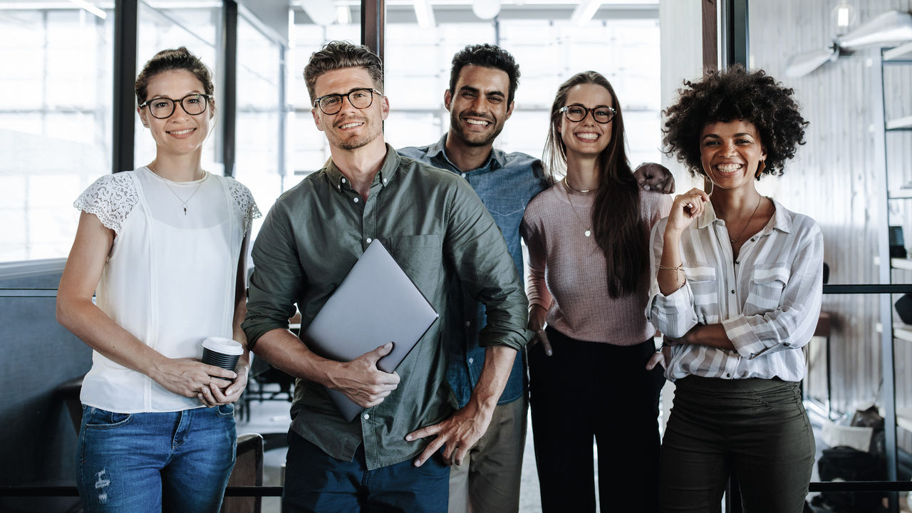 Picture of a successful creative business team looking at camera and smiling.