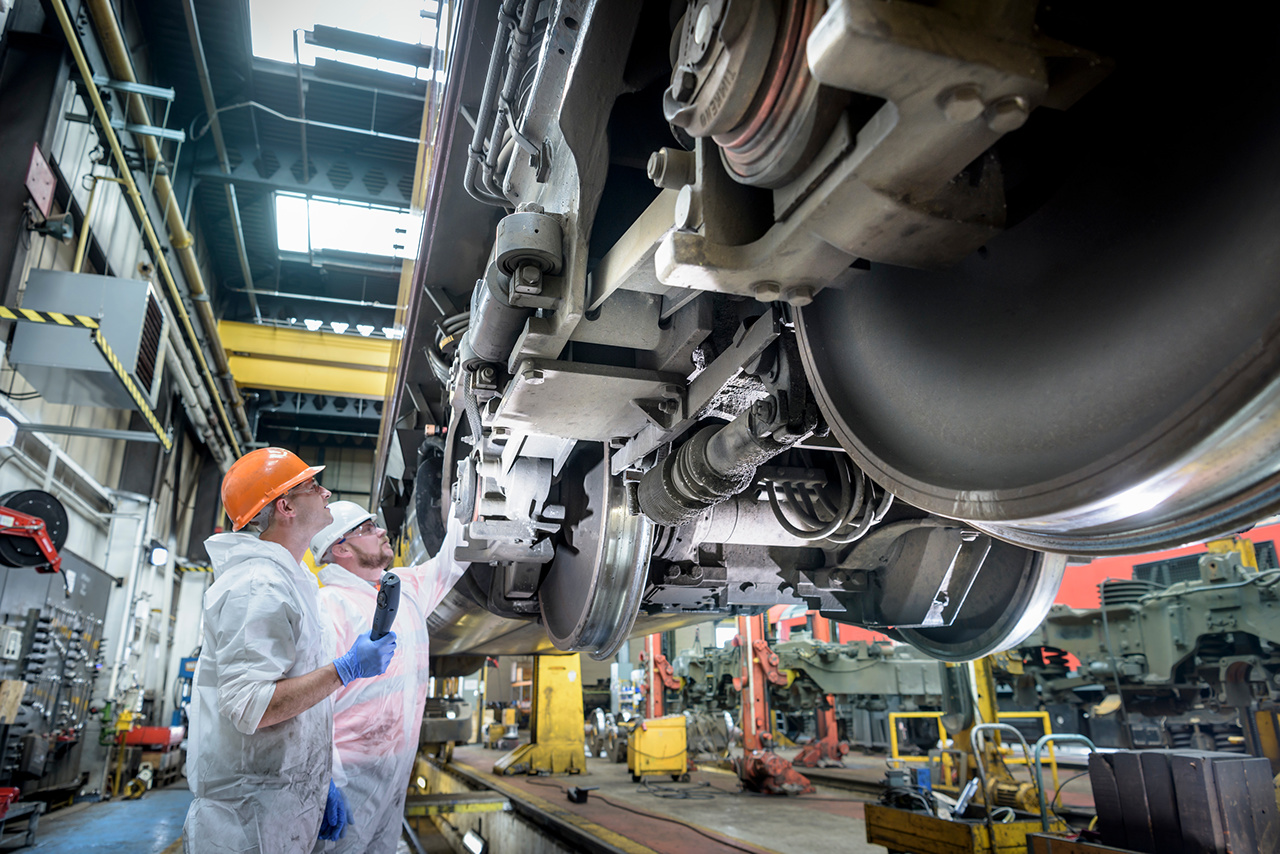 Locomotive engineers working on locomotive in train works